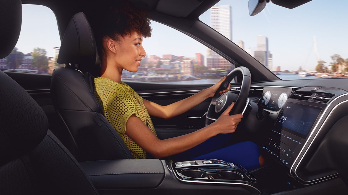 Kvinna kör Hyundai TUCSON med panoramatak.
