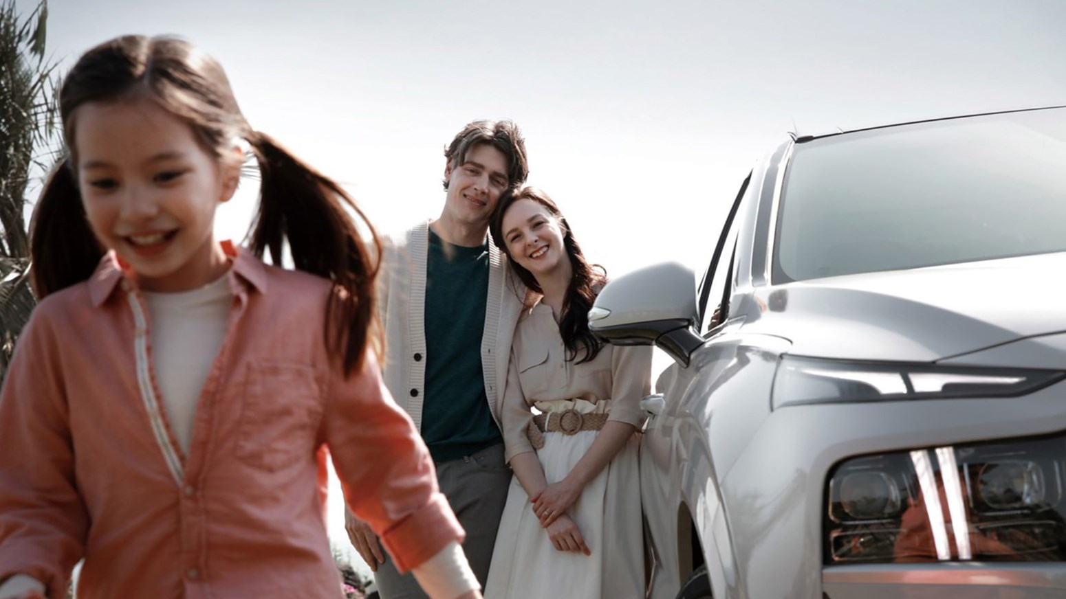 Bildgalleri - Ett barn och två vuxna vid sidan om Hyundai SANTA FE.
