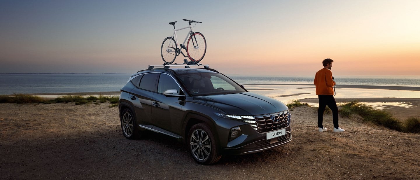 Hyundai TUCSON Plug-in Hybrid på strand med tillbehör cykelhållare.