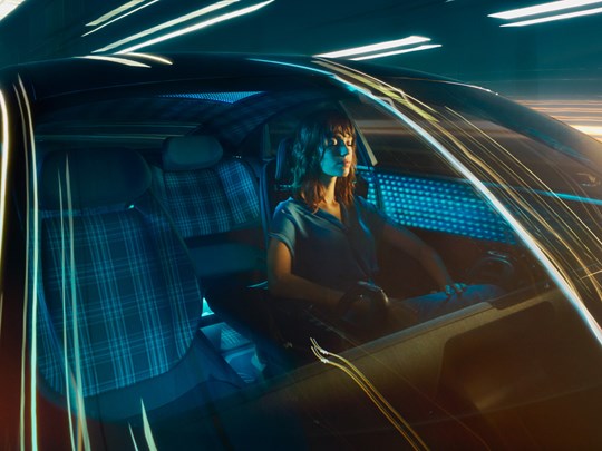 Kvinna sitter i futuristisk elbil.