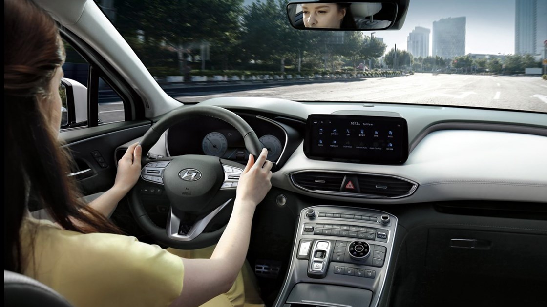 En kvinna kör Hyundai SANTA FE Plug-in Hybrid.