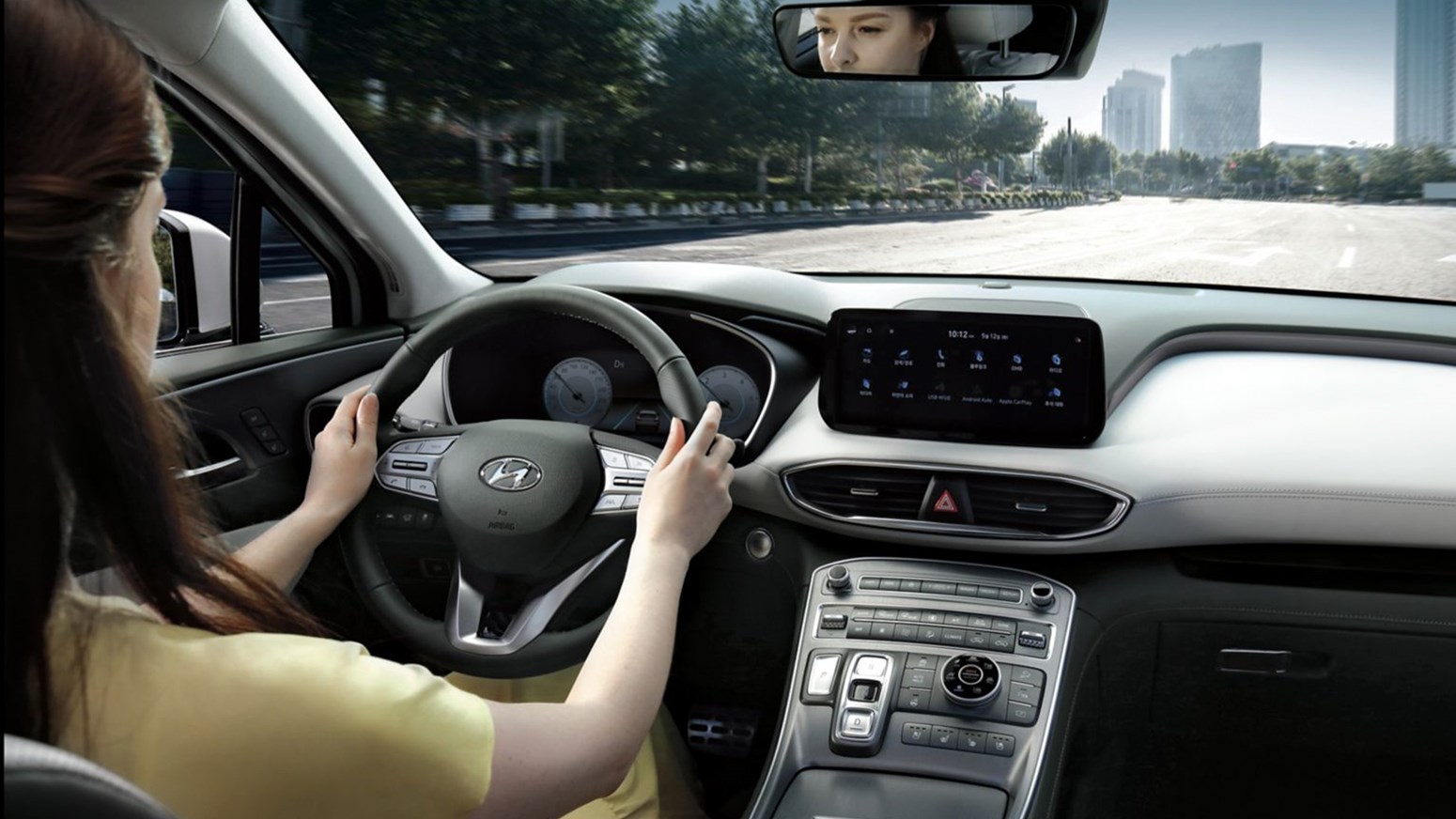 Bildgalleri - en kvinna i gult klädesplagg kör Hyundai SANTA FE Plug-in Hybrid.