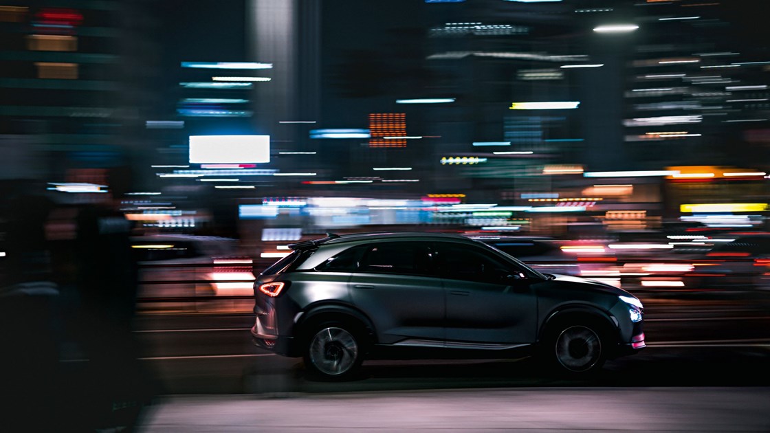 En Hyundai i nattlig stadsmiljö med neonljus.
