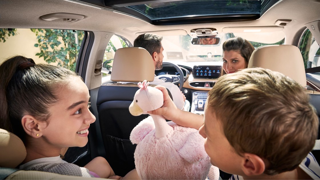 En familj med fyra personer sitter i en Hyundai SANTA FE Hybrid.